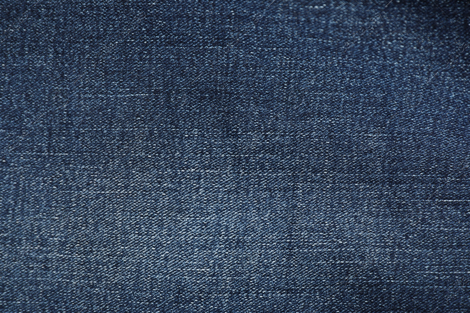 Photo of Texture of dark blue jeans as background, top view