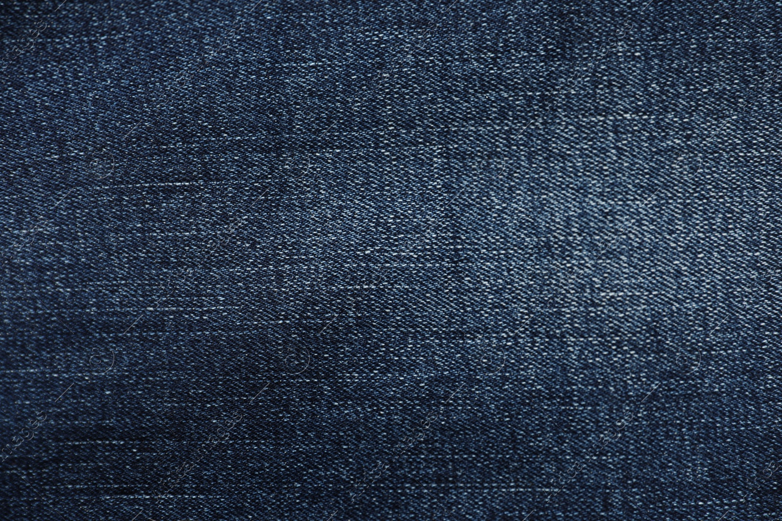 Photo of Texture of dark blue jeans as background, top view