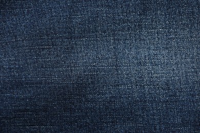 Photo of Texture of dark blue jeans as background, top view