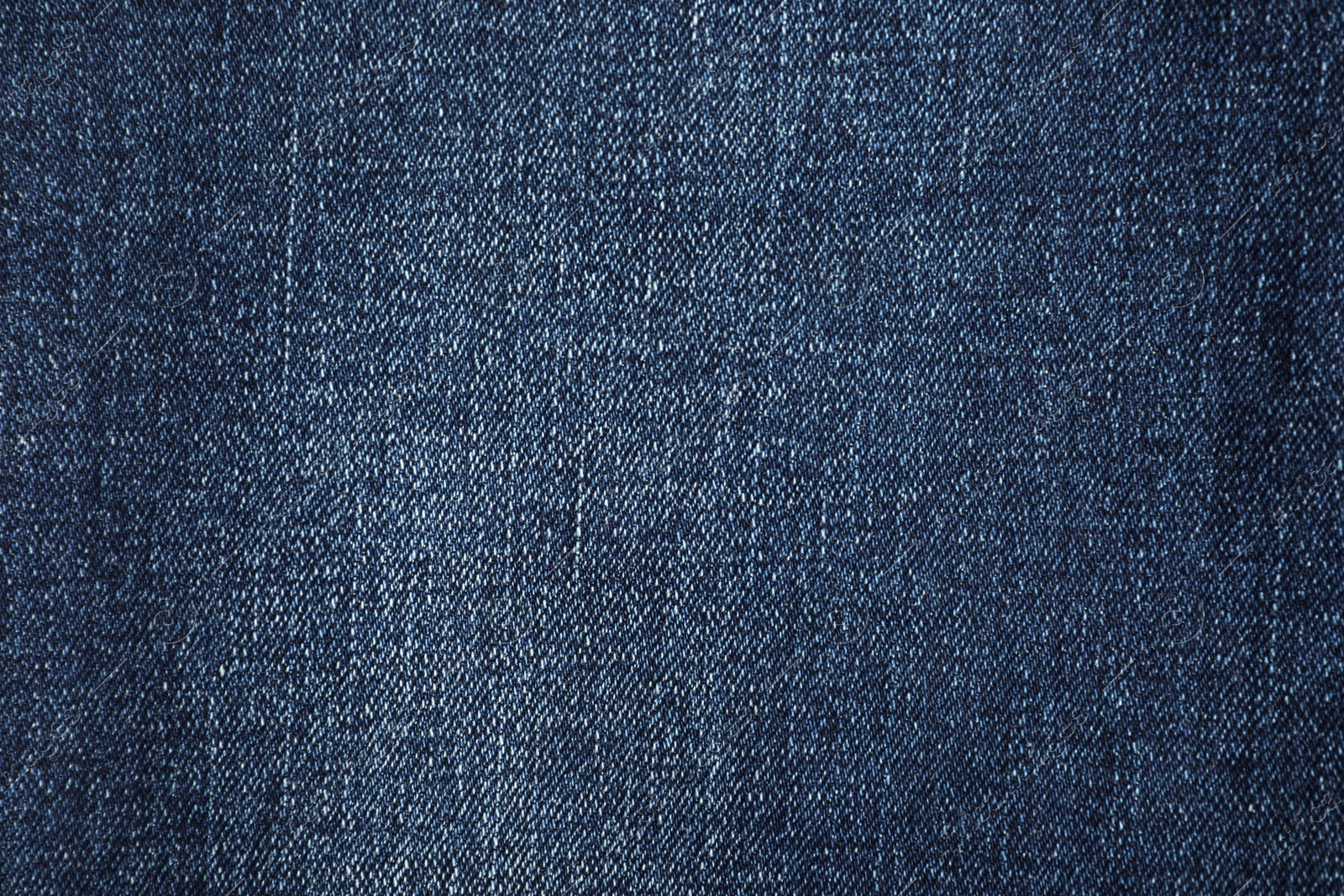 Photo of Texture of dark blue jeans as background, top view