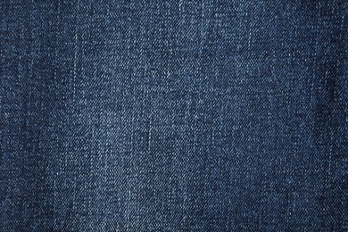 Photo of Texture of dark blue jeans as background, top view