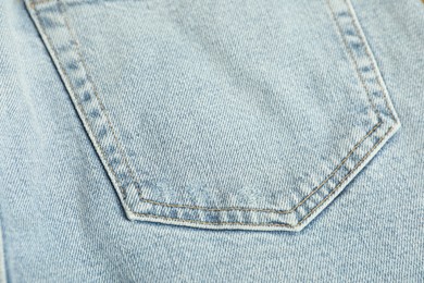 Photo of Stylish light blue jeans with pocket as background, top view