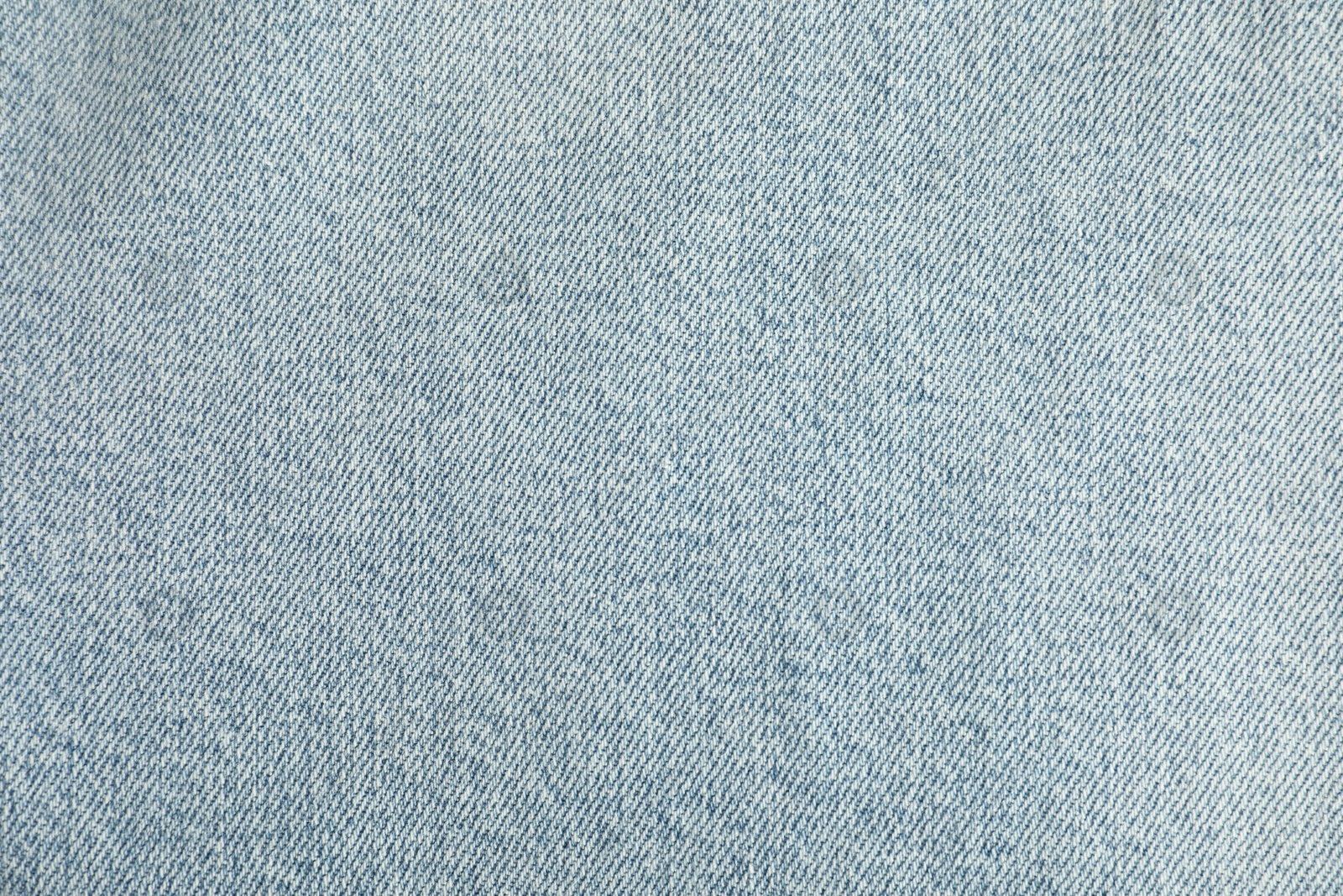 Photo of Texture of light blue jeans as background, top view