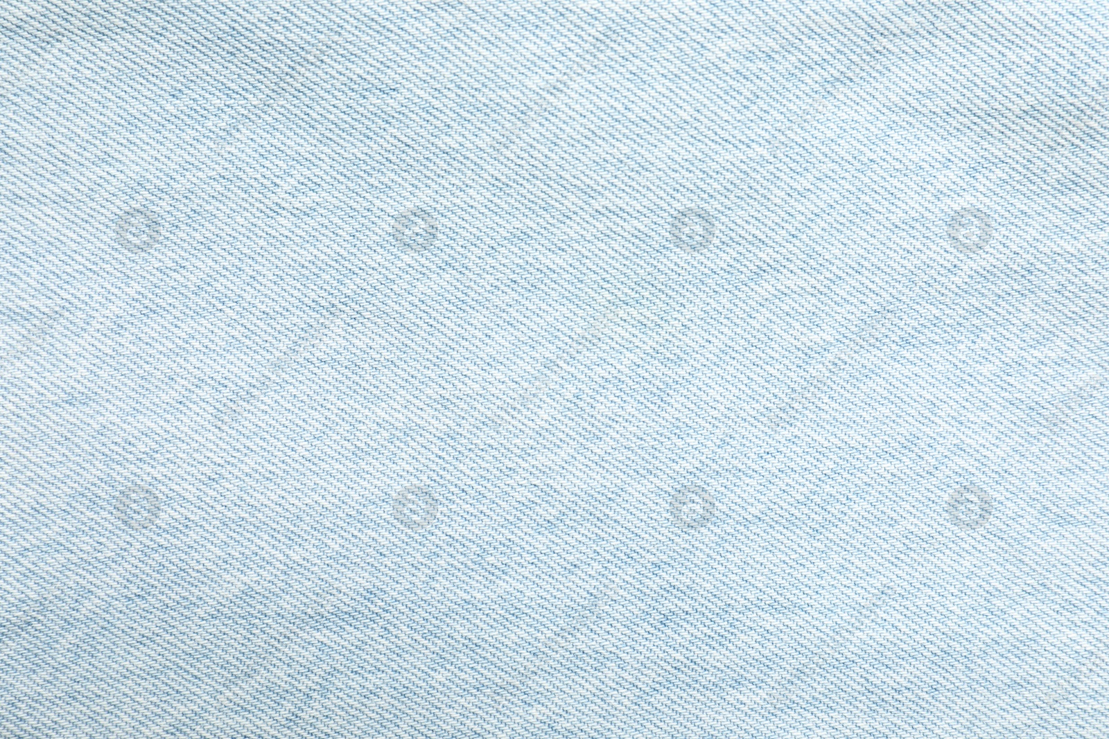 Photo of Texture of light blue jeans as background, top view