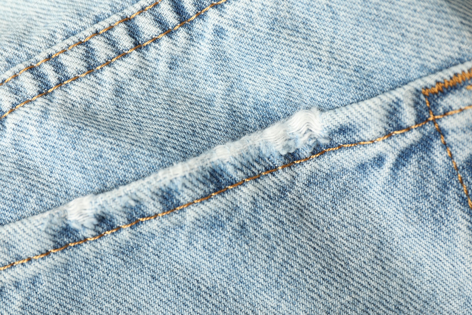 Photo of Ripped light blue jeans with pocket as background, top view