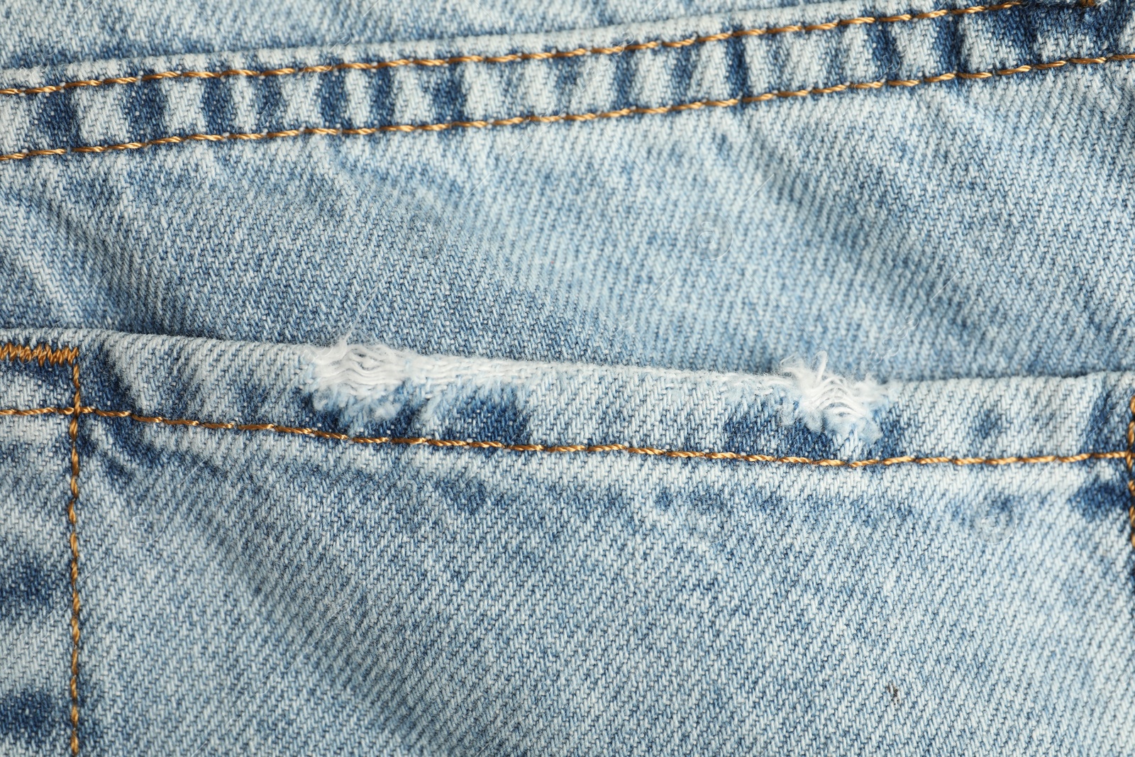 Photo of Ripped light blue jeans with pocket as background, top view