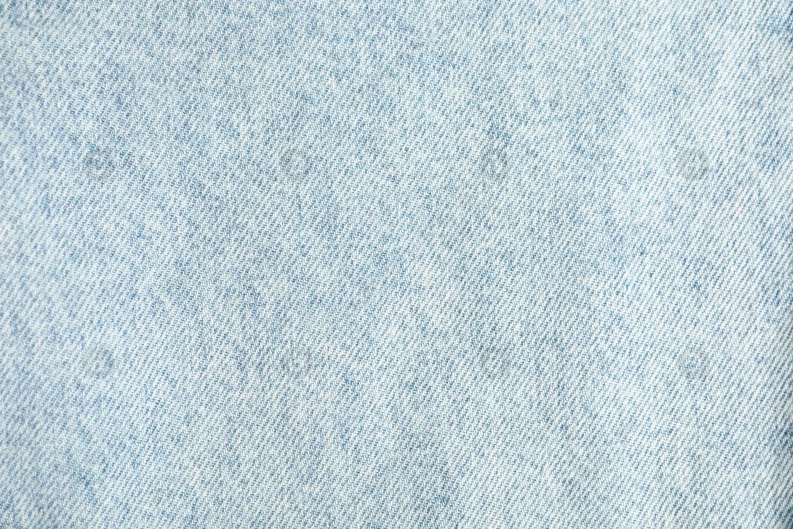 Photo of Texture of light blue jeans as background, top view