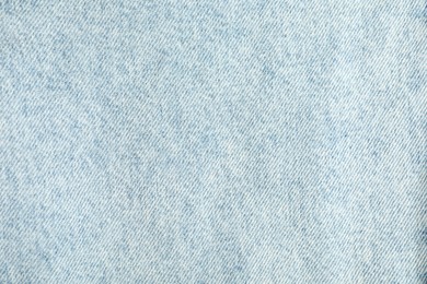 Photo of Texture of light blue jeans as background, top view