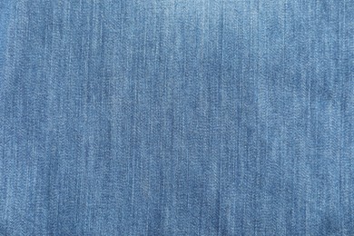 Photo of Texture of blue jeans as background, top view