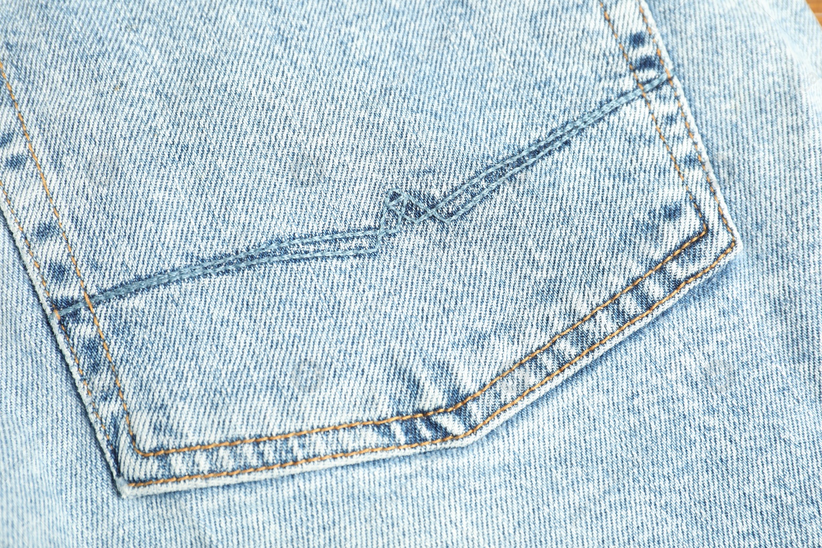 Photo of Stylish light blue jeans with pocket as background, top view