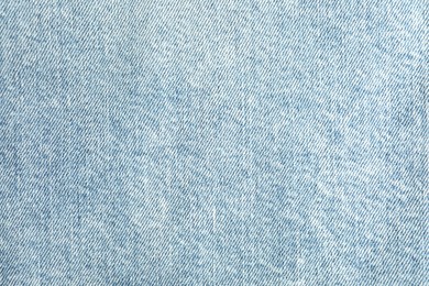 Photo of Texture of light blue jeans as background, top view