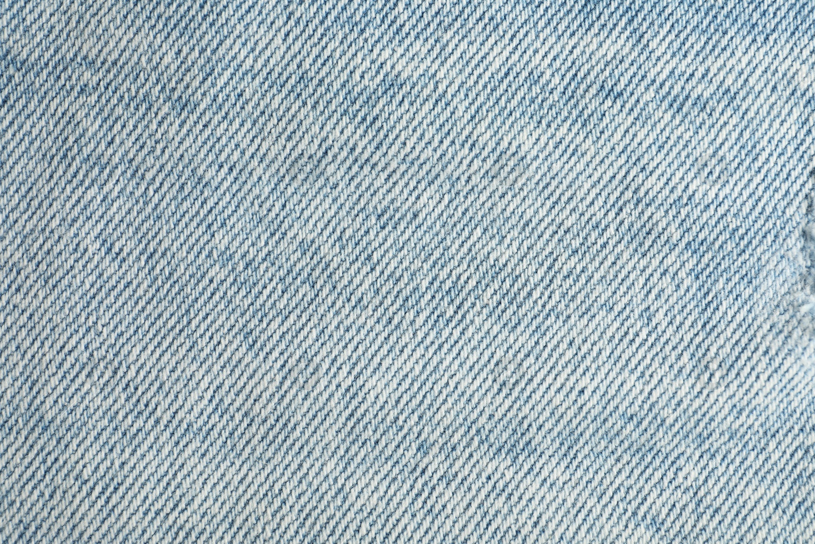 Photo of Texture of light blue jeans as background, top view