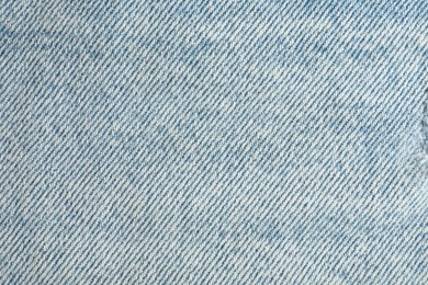 Photo of Texture of light blue jeans as background, top view