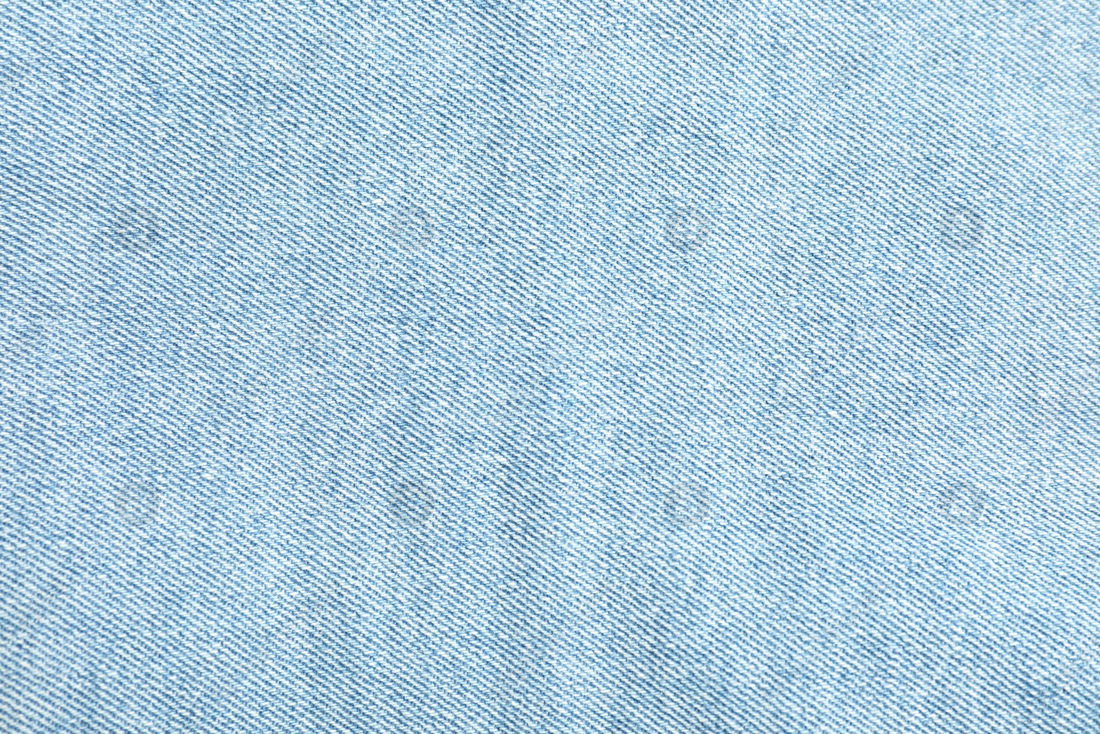 Photo of Texture of light blue jeans as background, top view