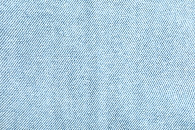 Photo of Texture of light blue jeans as background, top view