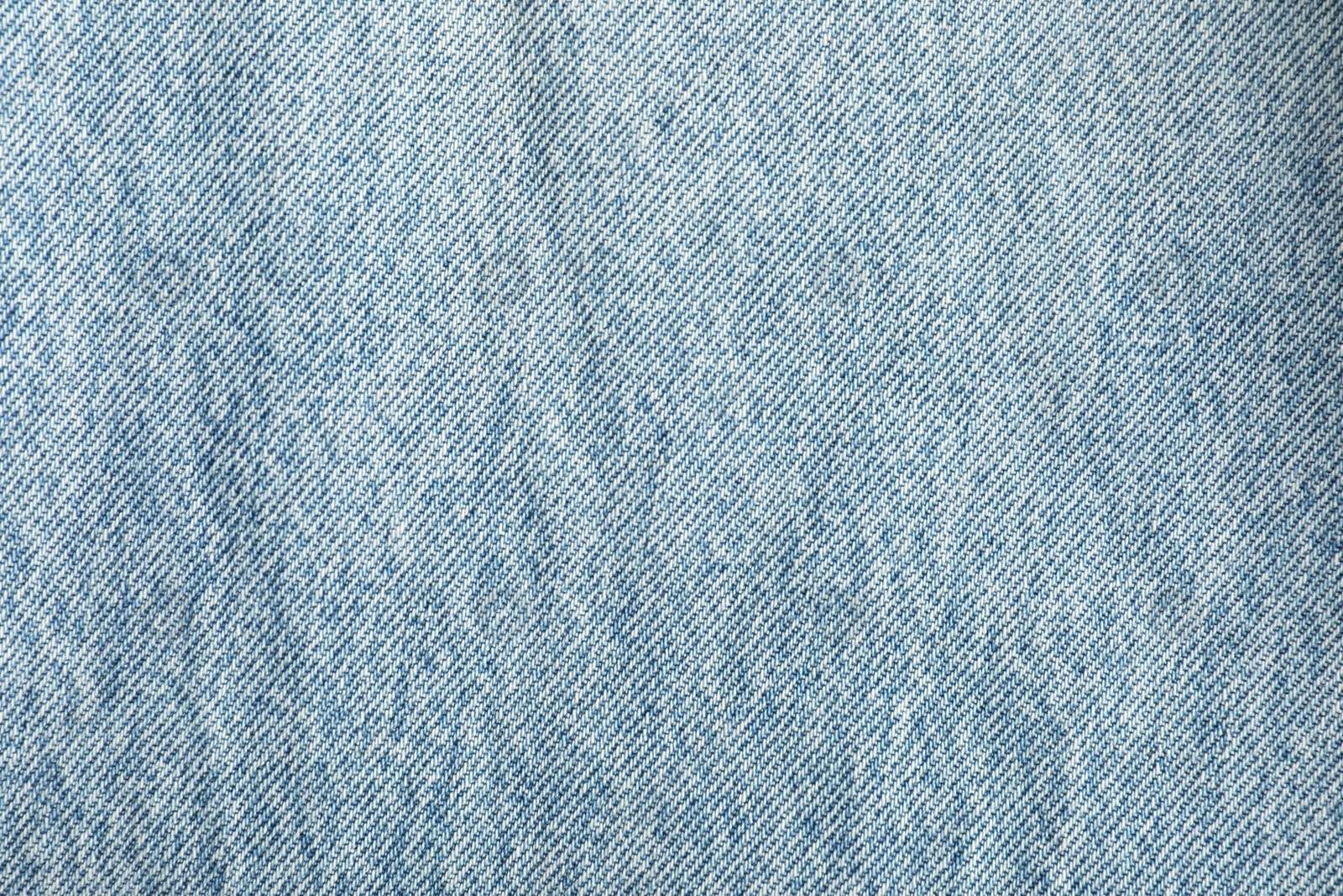 Photo of Texture of light blue jeans as background, top view