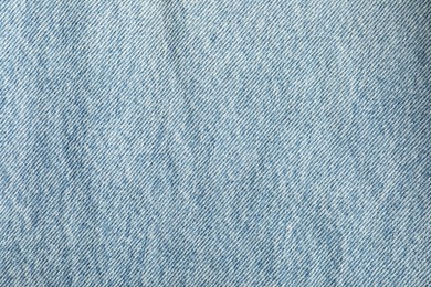 Photo of Texture of light blue jeans as background, top view