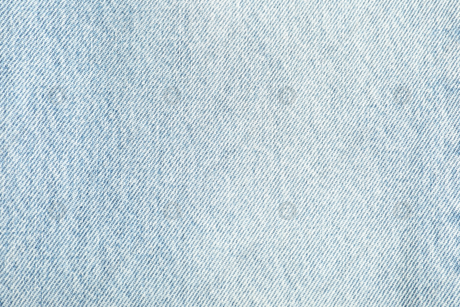 Photo of Texture of light blue jeans as background, top view