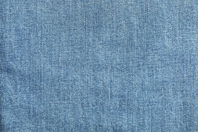 Photo of Texture of blue jeans as background, top view