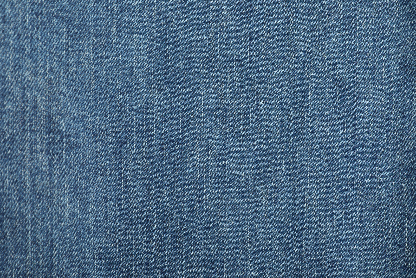 Photo of Texture of blue jeans as background, top view