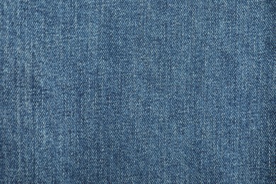 Photo of Texture of blue jeans as background, top view