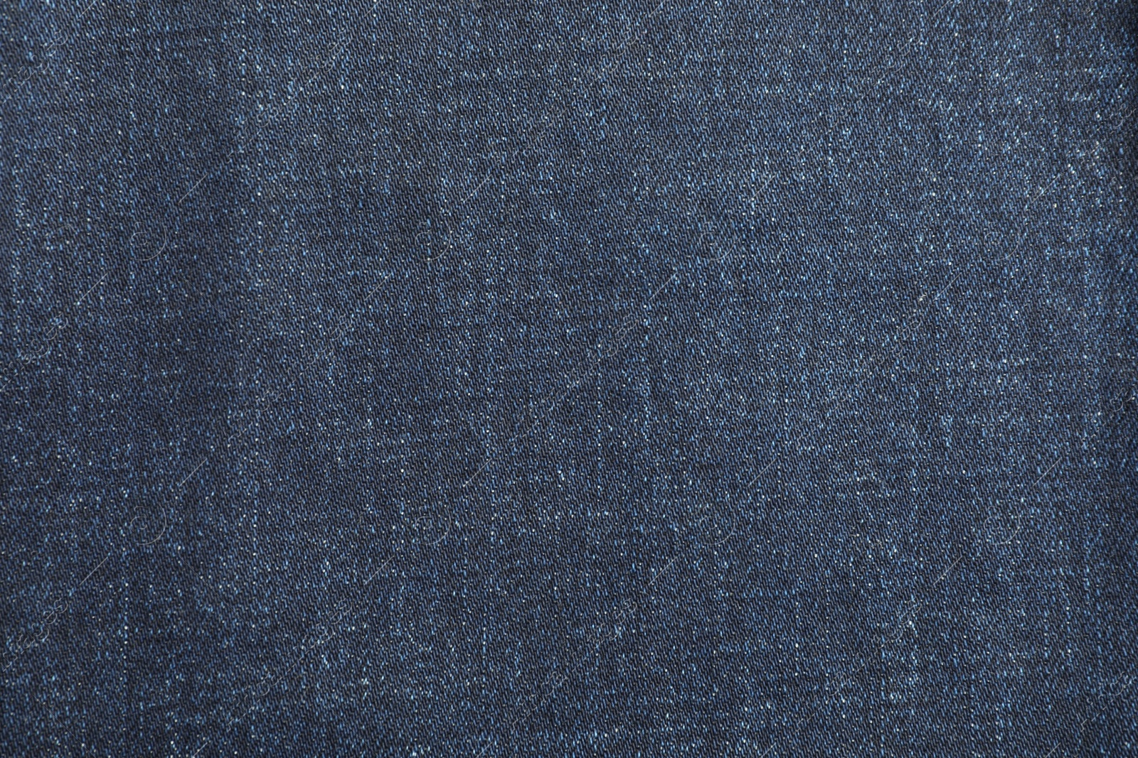 Photo of Texture of dark blue jeans as background, top view