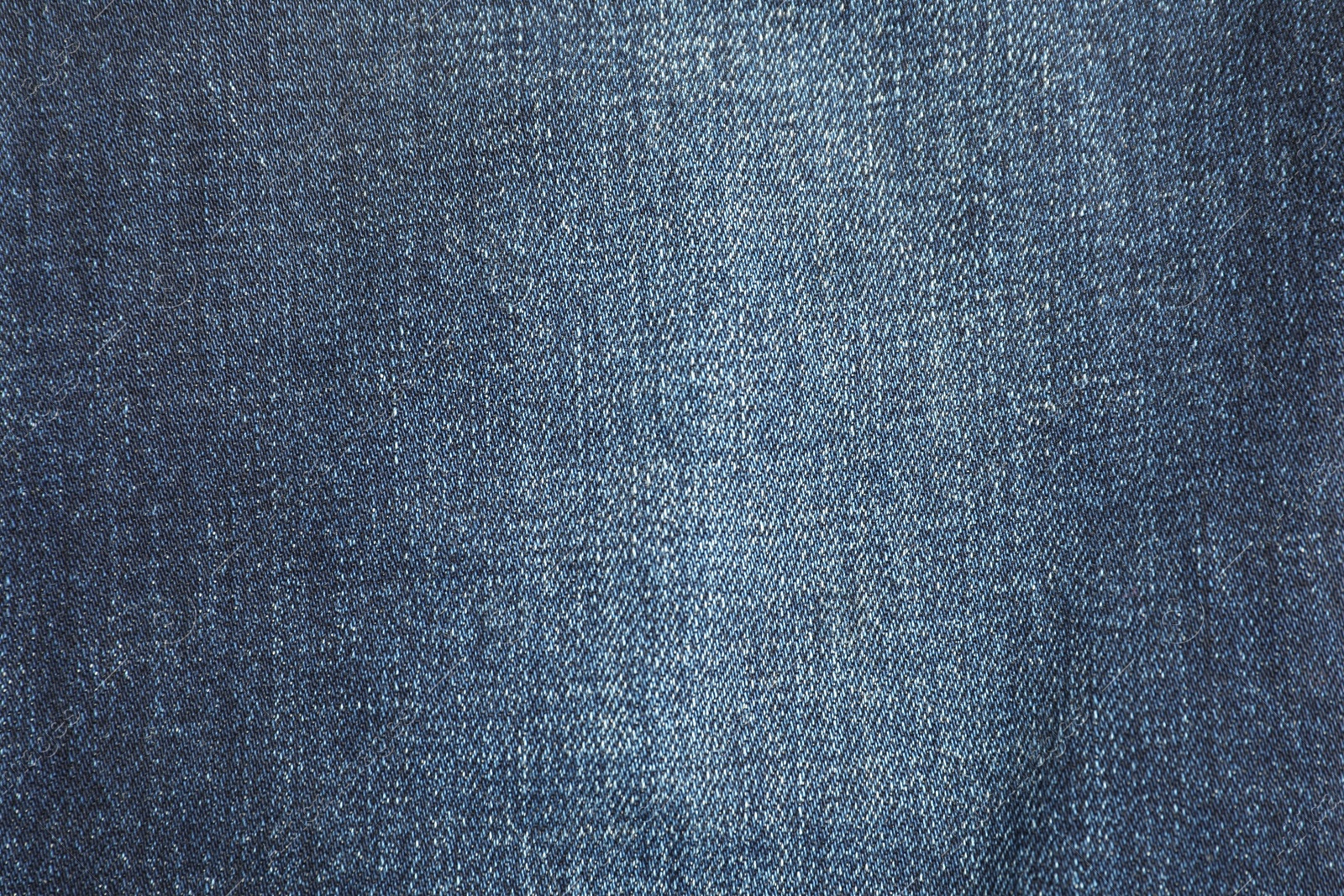 Photo of Texture of dark blue jeans as background, top view