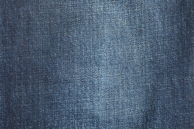 Photo of Texture of dark blue jeans as background, top view