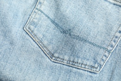 Photo of Stylish light blue jeans with pocket as background, top view