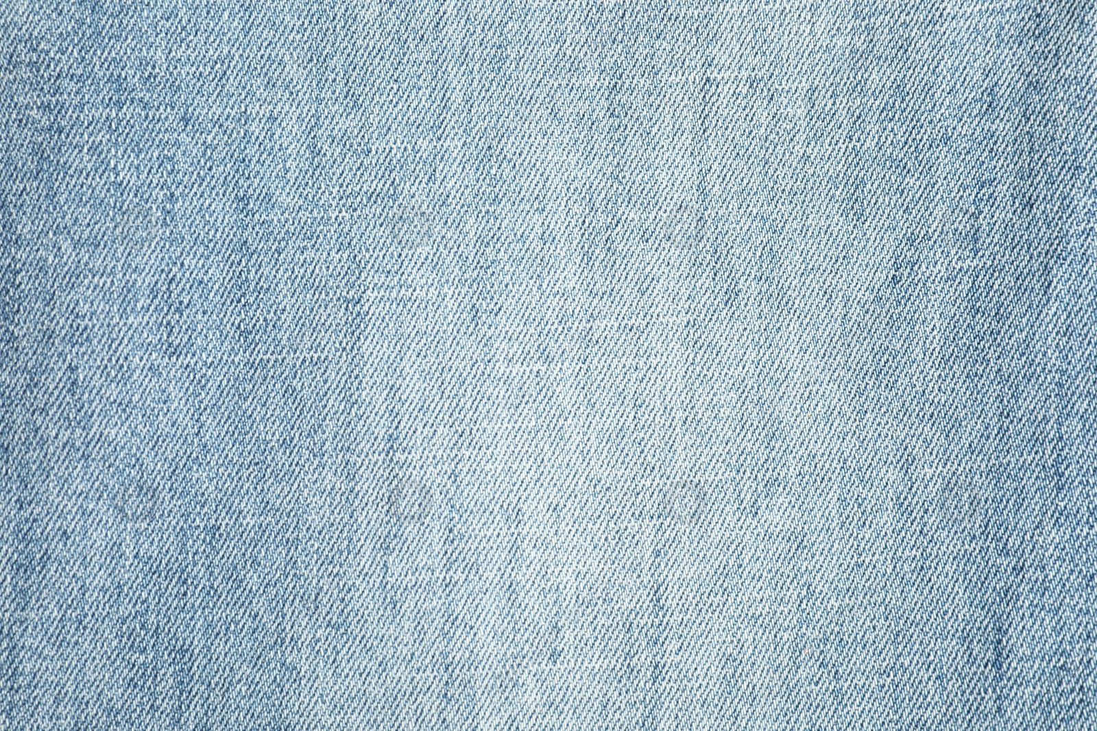 Photo of Texture of light blue jeans as background, top view