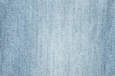 Photo of Texture of light blue jeans as background, top view