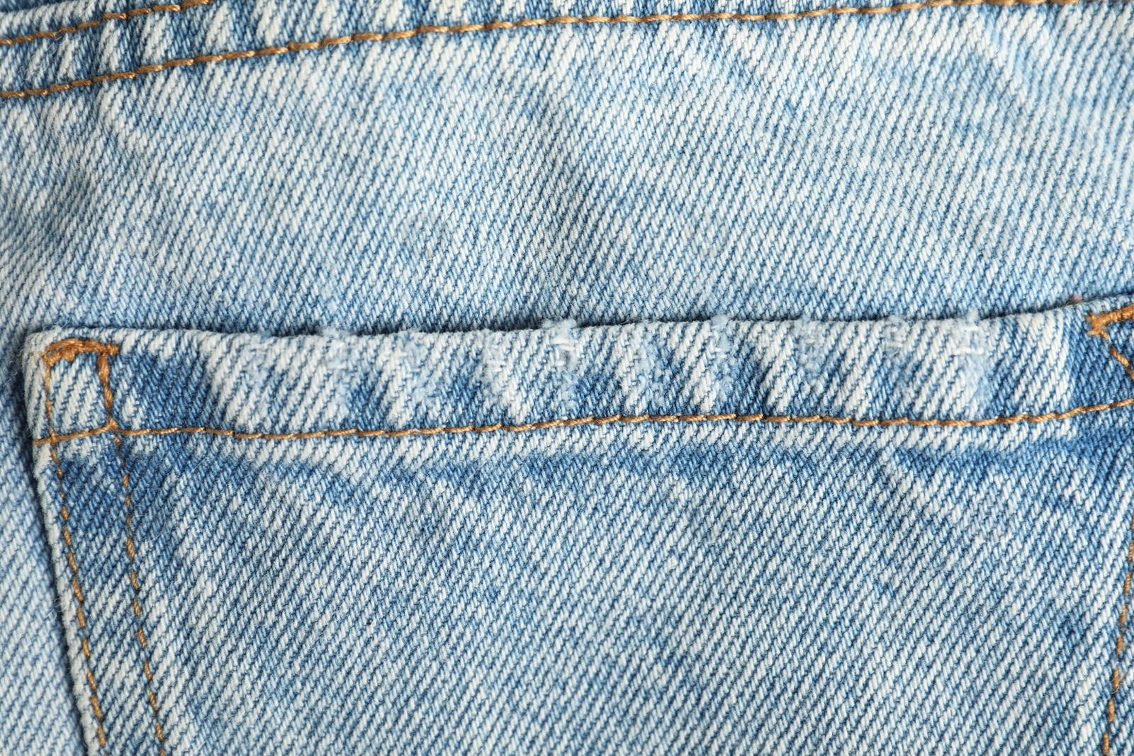 Photo of Stylish light blue jeans with pocket as background, top view