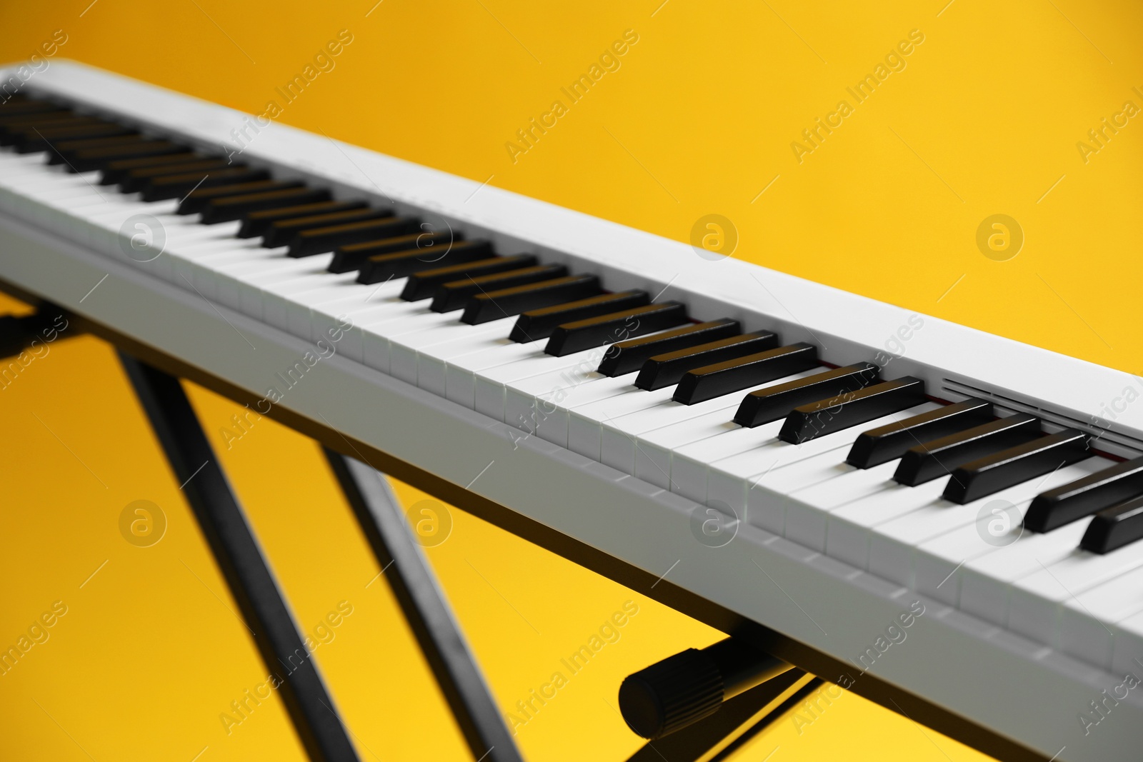 Photo of Synthesizer on yellow background, closeup. Electronic musical instrument