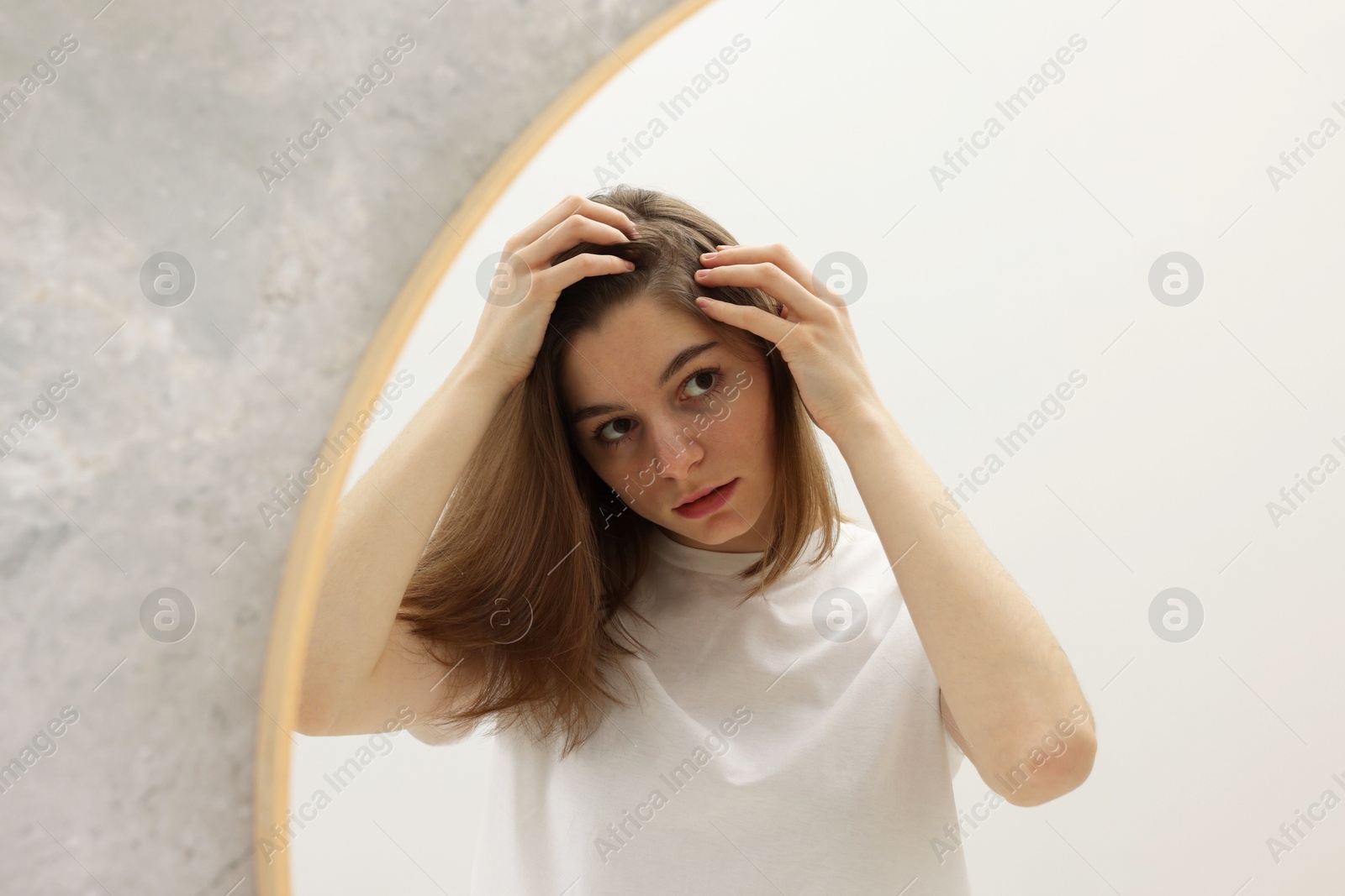 Photo of Girl with hair loss problem near mirror in bathroom, space for text