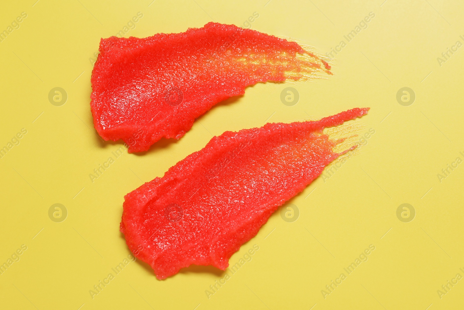 Photo of Samples of body scrub on yellow background, top view