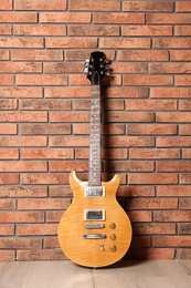 Photo of One modern electric guitar near brick wall