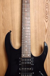 One modern electric guitar on wooden background, closeup