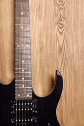 Photo of One modern electric guitar on wooden background, closeup