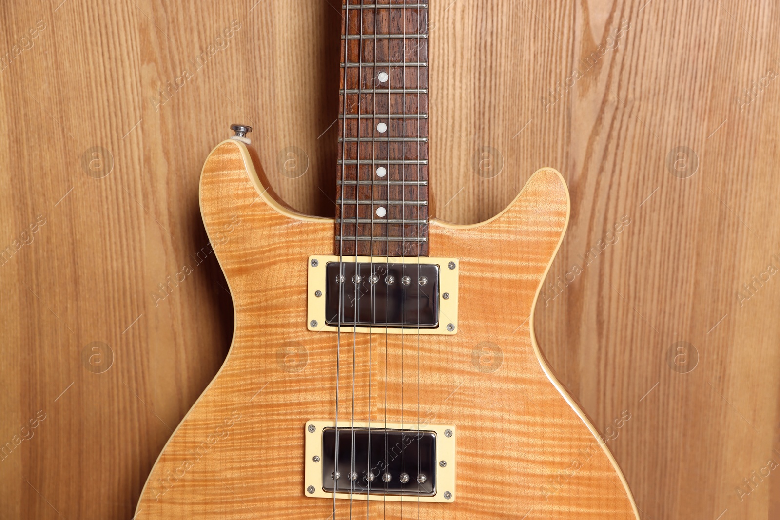 Photo of One modern electric guitar on wooden background, closeup