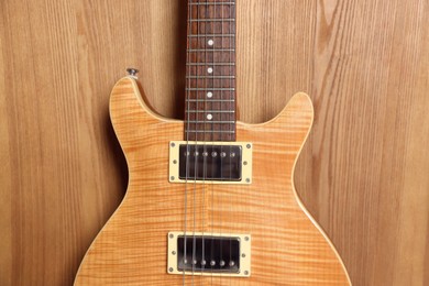 Photo of One modern electric guitar on wooden background, closeup