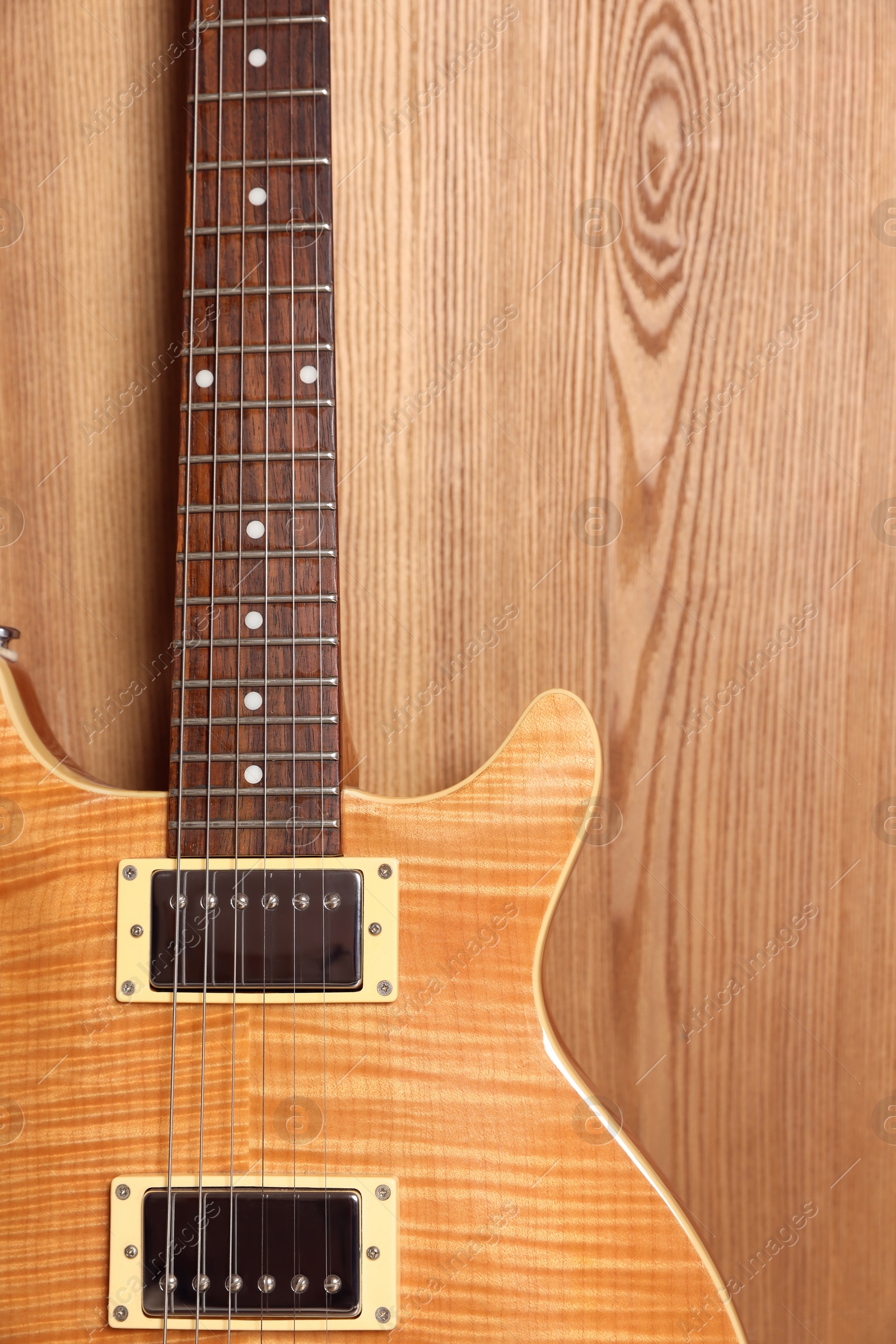 Photo of One modern electric guitar on wooden background, closeup