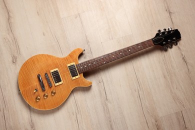 Photo of One modern electric guitar on wooden background, top view