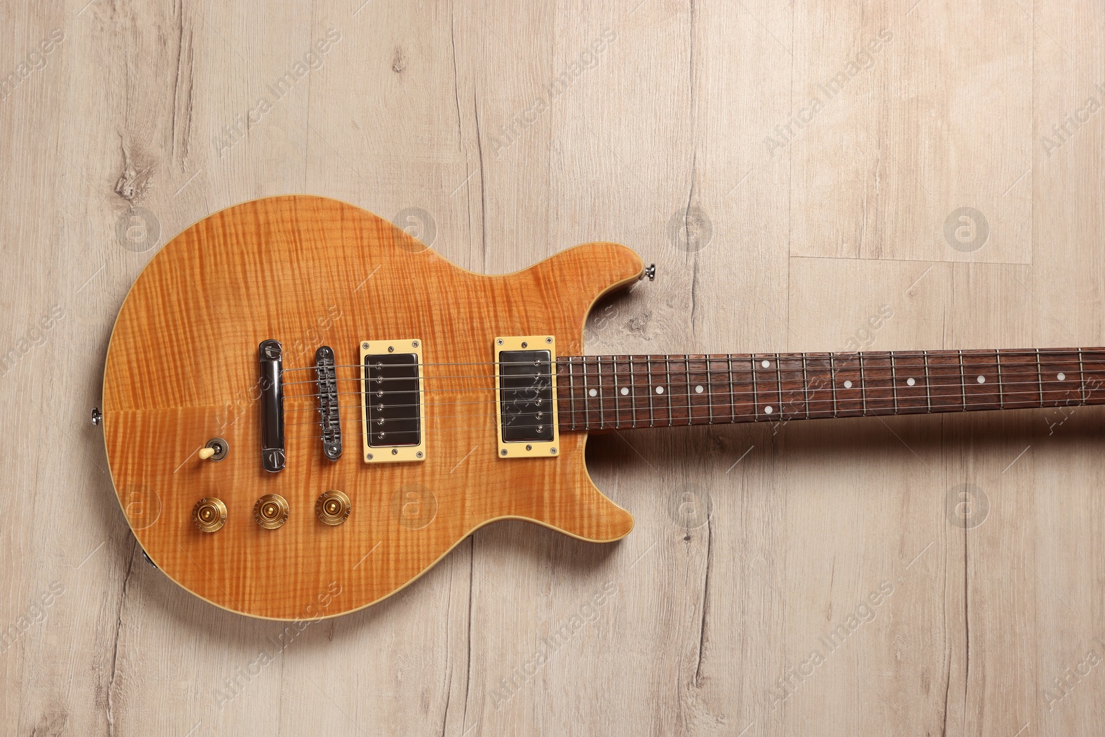 Photo of One modern electric guitar on wooden background, top view