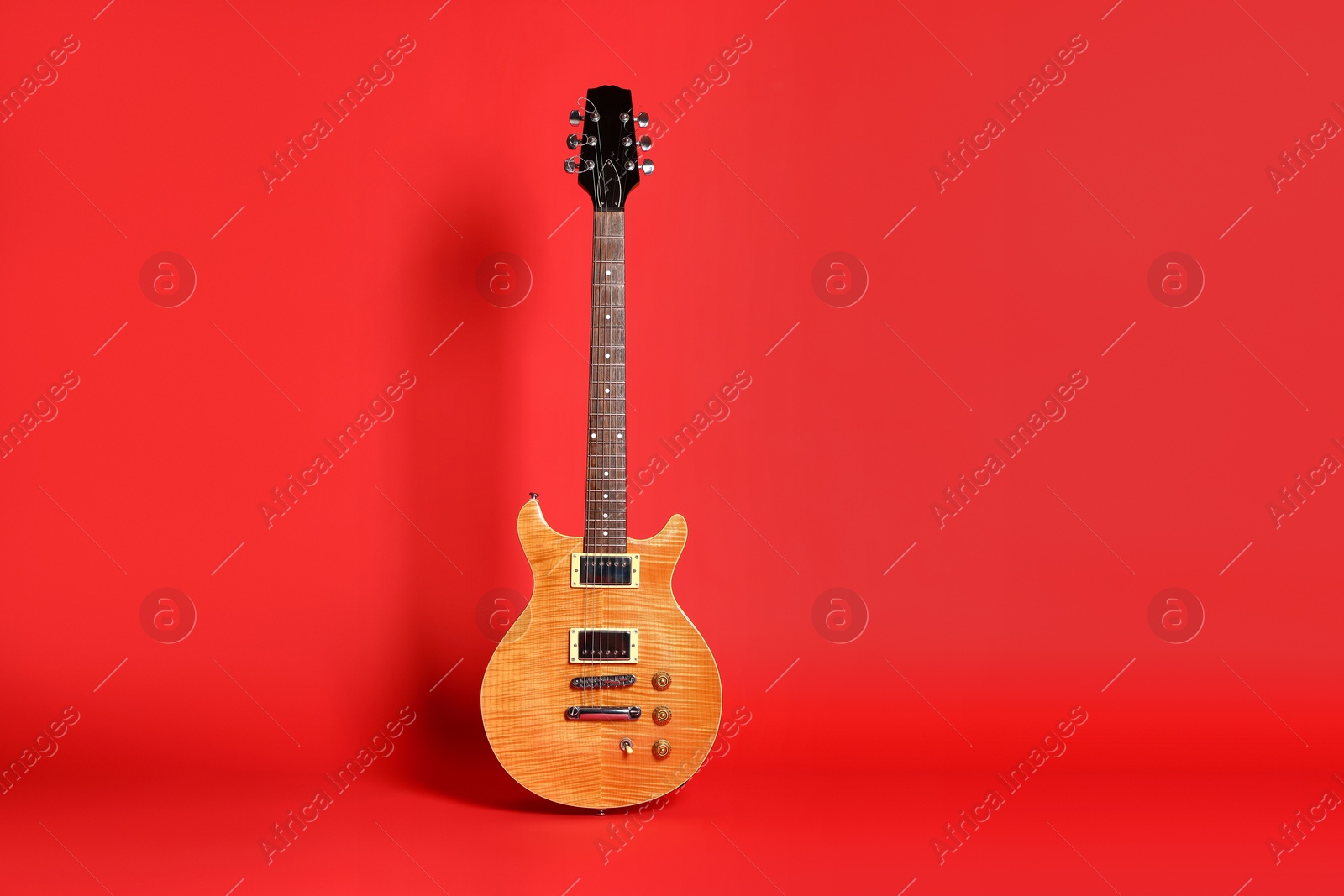 Photo of One modern electric guitar on red background