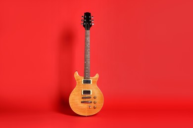 Photo of One modern electric guitar on red background