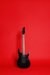 Photo of One modern electric guitar on red background