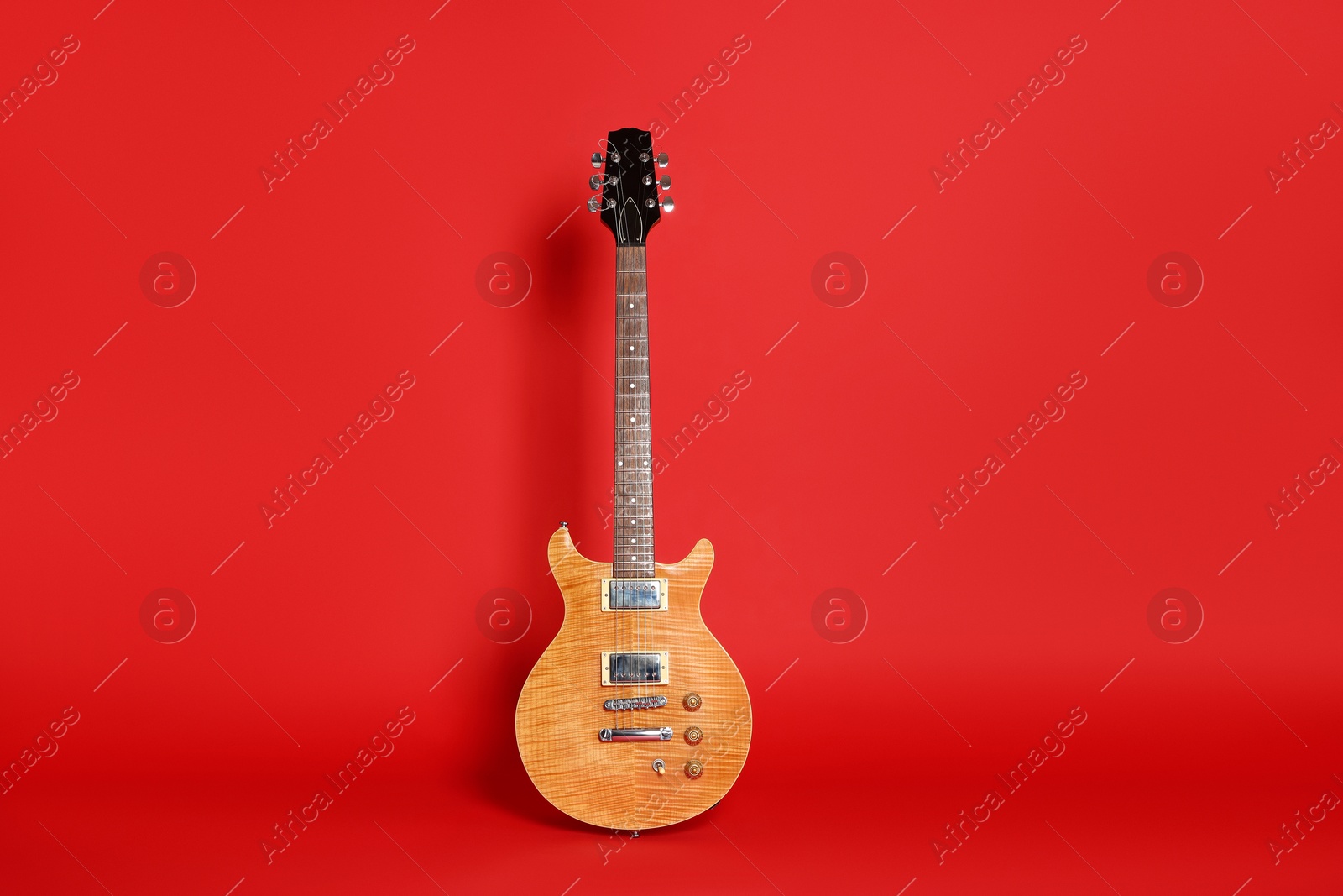 Photo of One modern electric guitar on red background