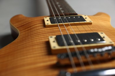 Photo of Modern electric guitar on grey background, closeup