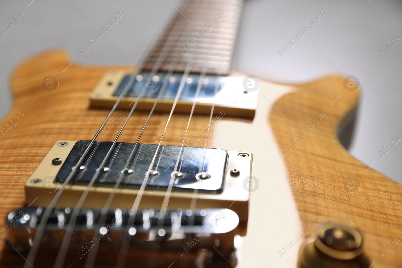 Photo of Modern electric guitar on grey background, closeup