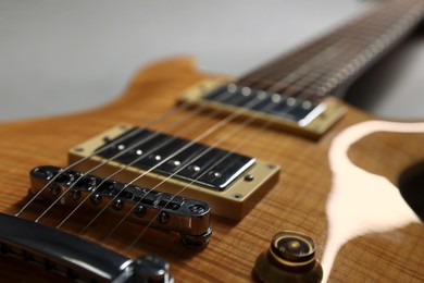 Photo of Modern electric guitar on grey background, closeup